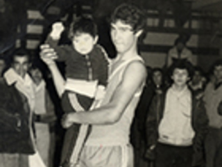 Basquetbolista con niño en brazos Basquetbolista con niño en brazos