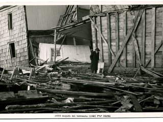 Dionisio Muñoz camina entre los escombros de un salón de billar. Año 1960. Ancud. Donada por José Caro Bahamonde.