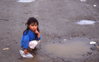 Niña juega en un charco de agua