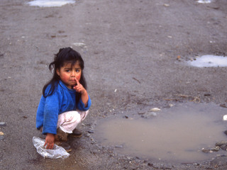 Niña juega en un charco de agua