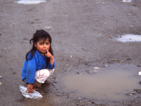 Niña juega en un charco de agua