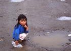 Niña juega en un charco de agua