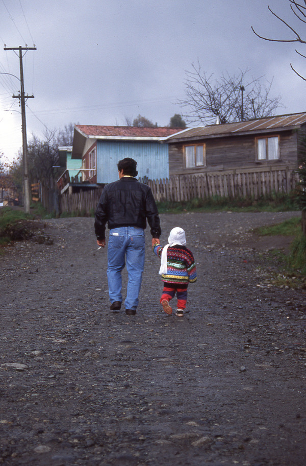 Padre e hijo caminan por la población Lolquellén