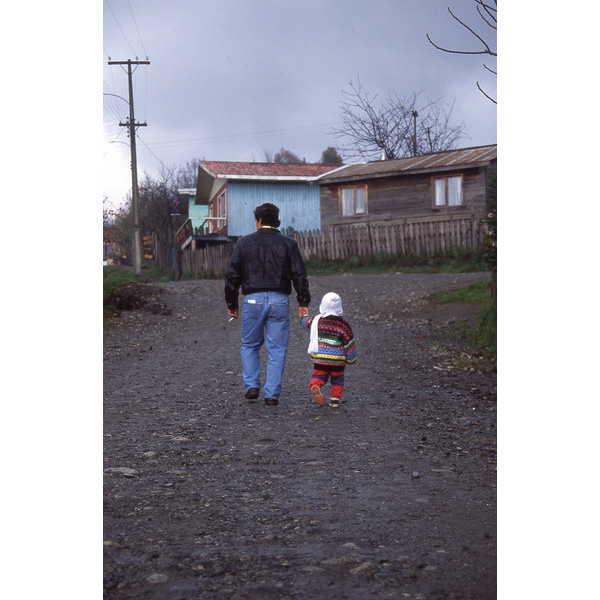 Padre e hijo caminan por la población Lolquellén