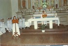 Niña exponiendo junto a niñas y sacerdote en Parroquia de Carén