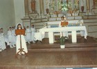 Niña exponiendo junto a niñas y sacerdote en Parroquia de Carén
