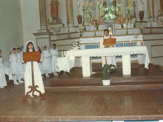 Niña exponiendo junto a niñas y sacerdote en Parroquia de Carén