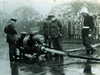 Voluntarios de la Tercera Compañía de Bomberos haciendo ajustes a la motobomba Bachert.