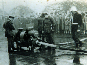 Voluntarios de la Tercera Compañía de Bomberos haciendo ajustes a la motobomba Bachert.